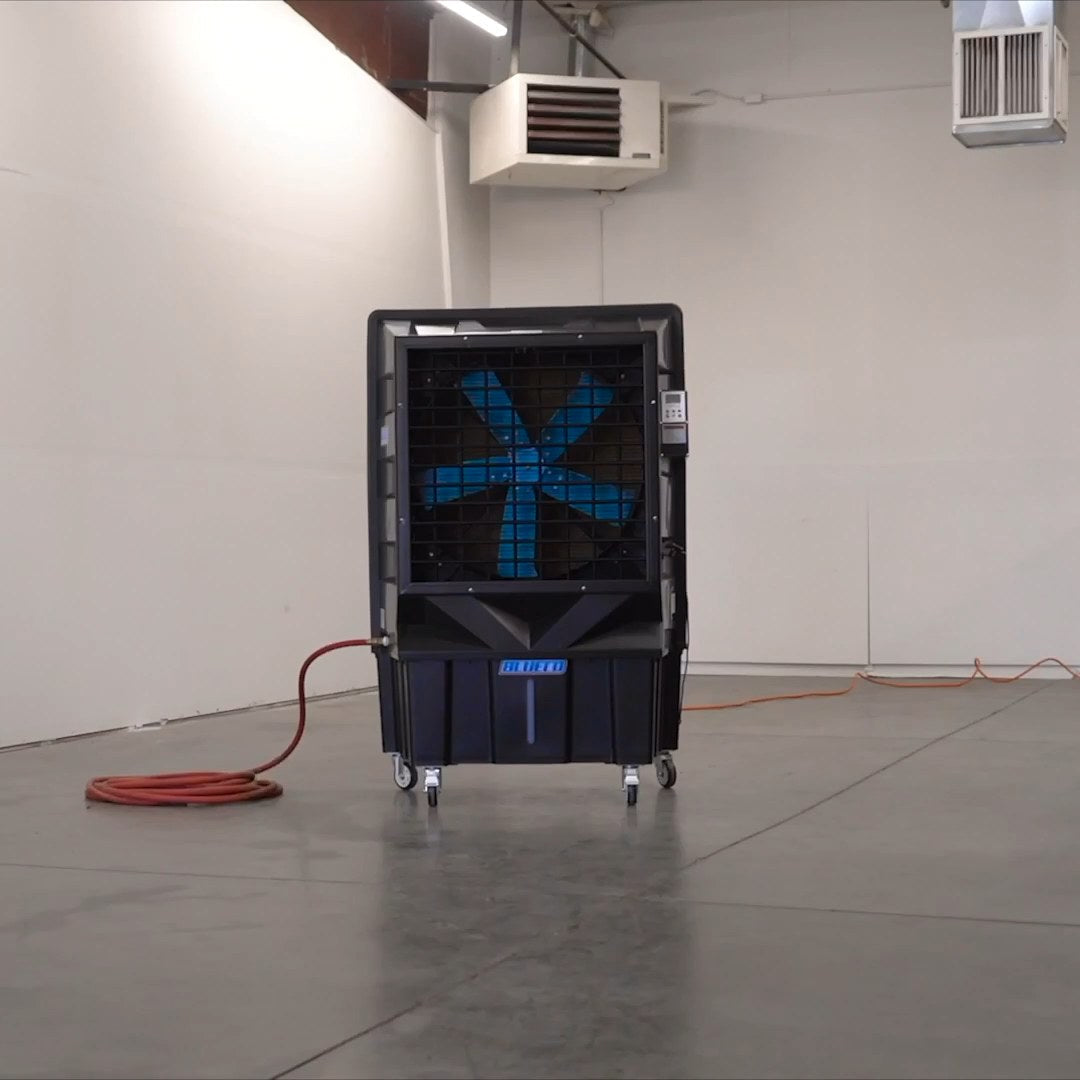 LEGACY-30 evaporative cooler on its casters in an empty bay, hose coiled beside it