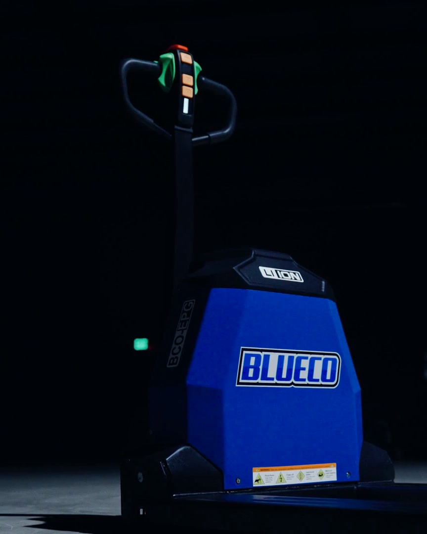 BLUECO electric pallet jack seen from the front, its badge lit in a dark warehouse